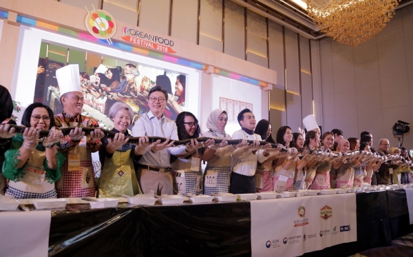 코리안 푸드 페스티벌에서 20m 김밥 말이 행사에서 완성한 대형 김밥을 보이고 있는 참가자들.