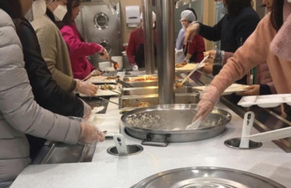 지난 26일 군포시청 직원들이 점심을 먹기 위해 방문한 구내식당에서 코로나19 예방 차원으로 비닐장갑을 착용한 채 음식을 담고 있다.  (사진제공 = 군포시)